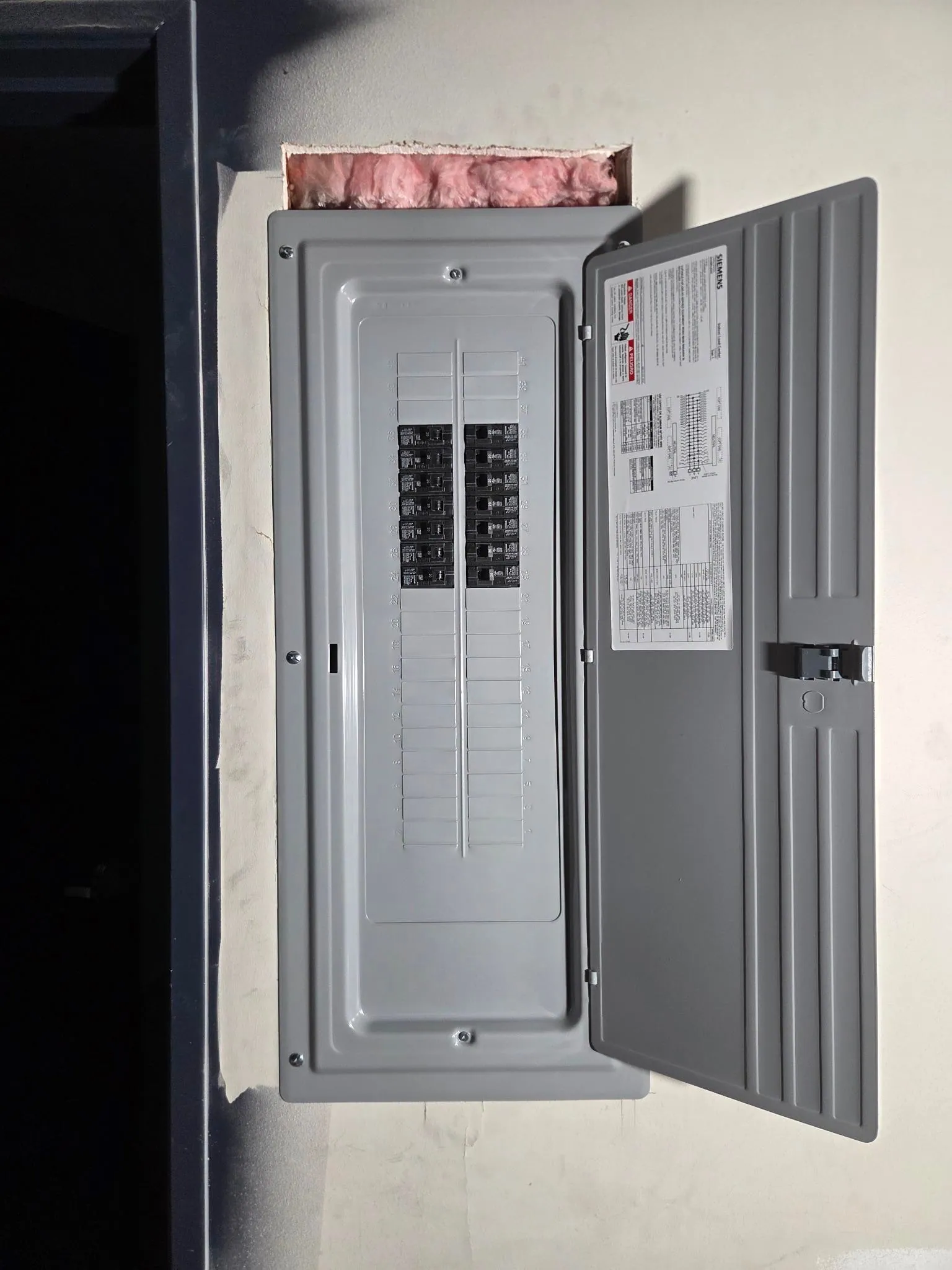 Completed home electrical panel with its labeled cover open
