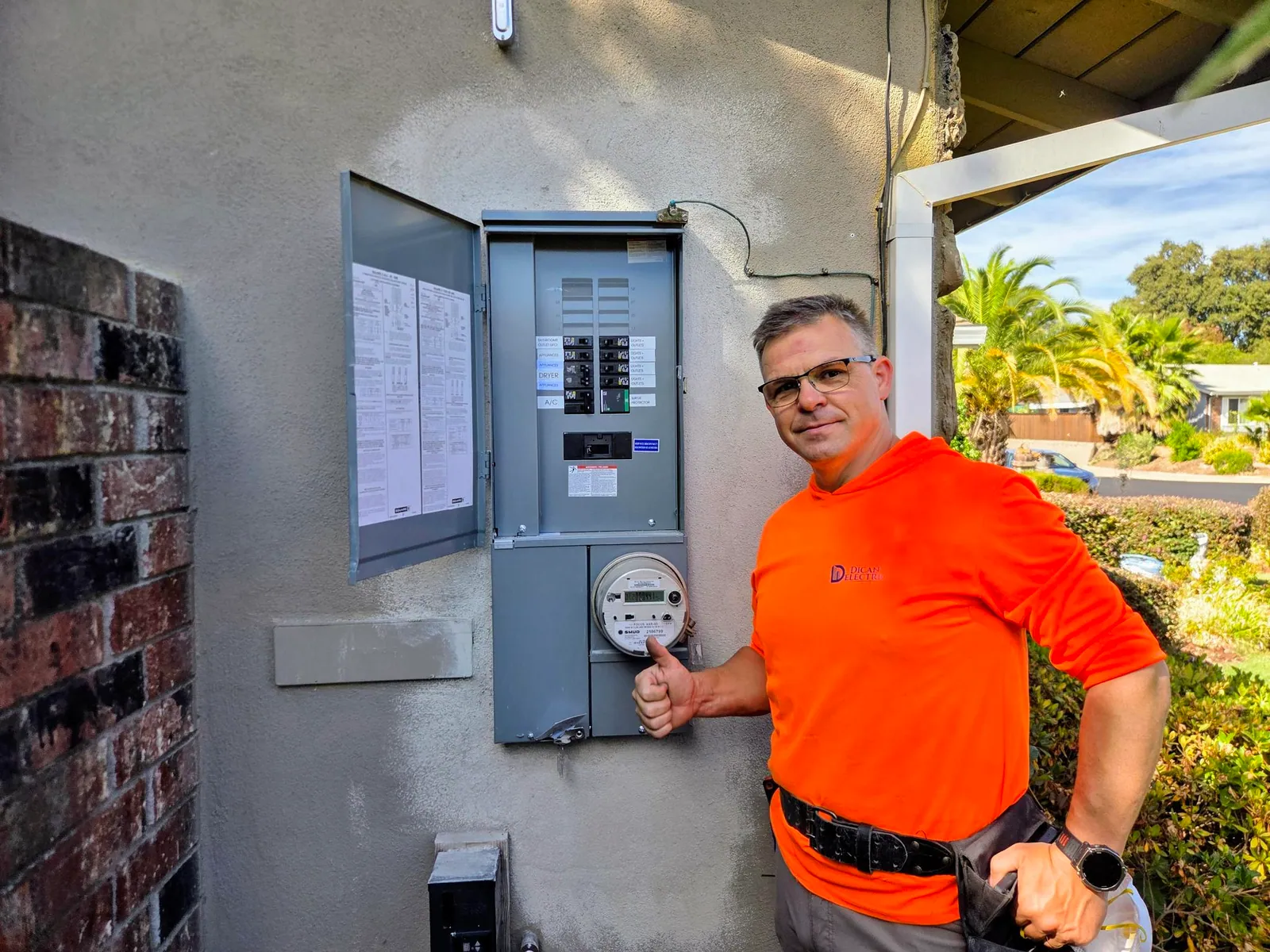 Dican Electric technician beside a newly installed residential electrical panel